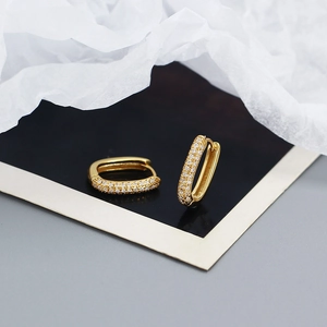 Macro shot of gold square hoop earrings with micro-pave cubic zirconia stones