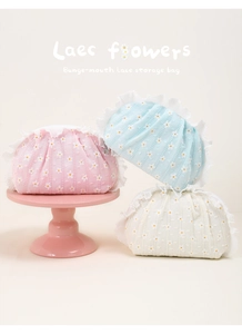 Close-up of floral embroidery on lace cosmetic bags with delicate ruffled edges