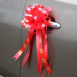 Red wedding bow with gold Xi character on grey car handle for festive decoration