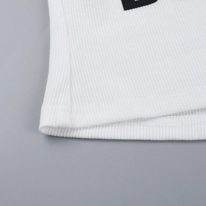 Close-up of white ribbed knit fabric showing hem stitching and soft texture detail