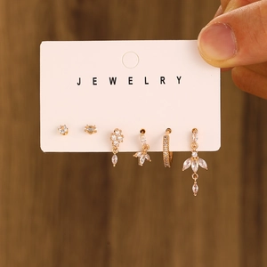 Close-up of 6-piece gold earring set with white zircons on a jewelry display card