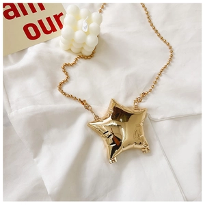 Detail of a shiny gold star-shaped mini crossbody bag with a beaded metal chain