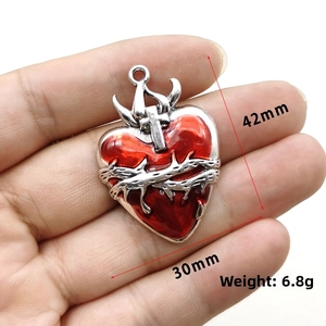 Detail shot of gothic red heart pendant with silver thorns and 42mm size dimensions