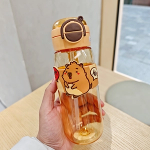 Tragbare Cartoon Capybara Trinkflasche mit Strohhalm und braunem Deckel in der Hand