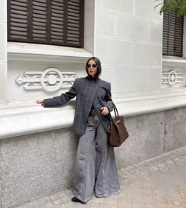 Gros plan du tissu écossais gris du blazer avec bouton unique et détails des poches