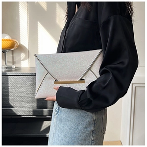 Détail d'une pochette enveloppe à paillettes blanches avec fermoir en métal doré chic