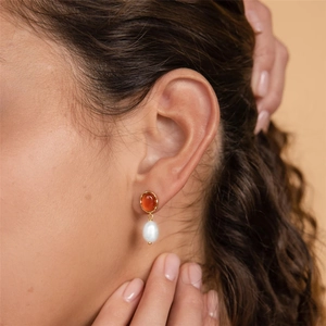 Detail of s925 silver retro hoop earring with red agate and white teardrop pearl on model
