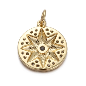 Macro view of gold starburst pendant with black center stone and star engraving