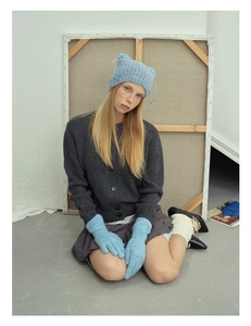 Detail of light blue cat ear knit beanie with delicate silk bow and matching gloves
