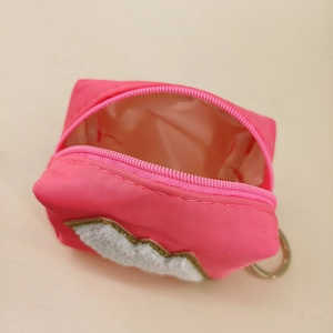 Detail der rosaroten Nylon-Münztasche mit weißem Flicken und Schlüsselanhänger