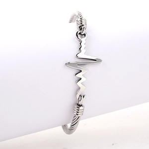 Detailed view of silver stainless steel ECG heartbeat cable bangle on display stand