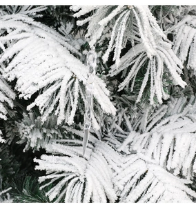 Detailed view of clear twisted icicle ornaments hanging on snow-covered Christmas tree branches