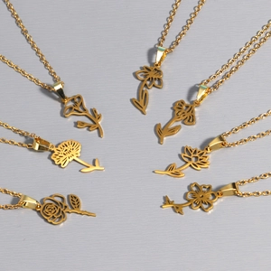 Detailed view of multiple 18k gold plated stainless steel necklaces with floral pendants
