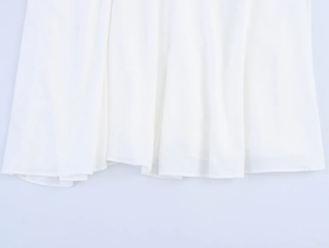 Close-up of the flowy white chiffon dress hem showing soft texture and natural drape