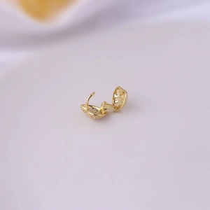 Macro shot of an open gold copper earring clasp with zircon inlay and hinged design