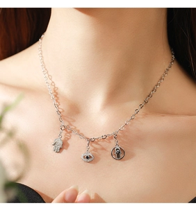 Detailed view of 925 silver necklace featuring Hamsa hand and sapphire evil eye pendants