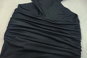 Detailed view of the side ruching and fabric texture on this black slim fit dress