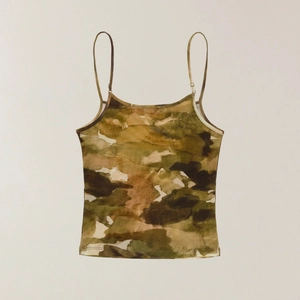 Detail of camouflaged tank top featuring adjustable thin straps and earthy color pattern