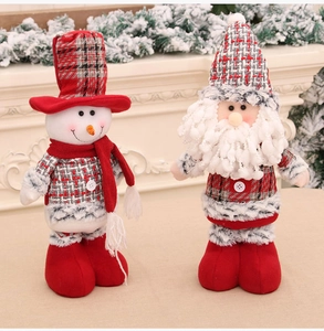 Festive Santa and Snowman plush dolls in red and grey plaid on a cozy mantle background