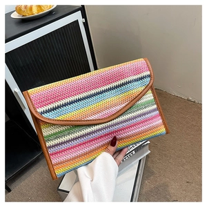 Detail of colorful striped straw clutch with envelope flap and brown trim texture