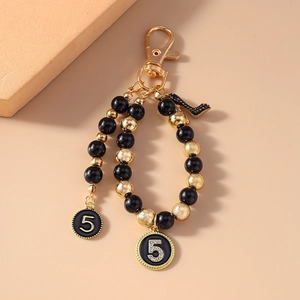 Beaded keychain with gold and black pearls, number 5 charms and high heel pendant