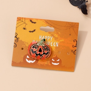 Macro shot of a pumpkin brooch with rhinestones and a Happy Halloween display card