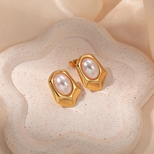 Vintage gold heart earrings with oval pearls on cream silk and textured tray