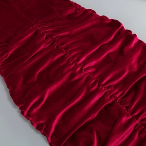 Gros plan sur le tissu en velours rouge foncé avec des détails plissés élégants