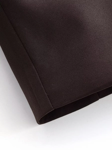 Detail shot of the high-quality dark brown fabric texture and hem stitching on the suit