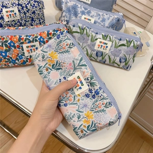 Close-up of floral fabric stationery pouches with purple zippers and embroidery patch