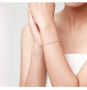 Close-up of minimalist S925 sterling silver gold snake chain bracelet on a woman wrist