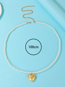 Detail view of 100cm pearl body chain with a golden heart pendant and lobster clasp