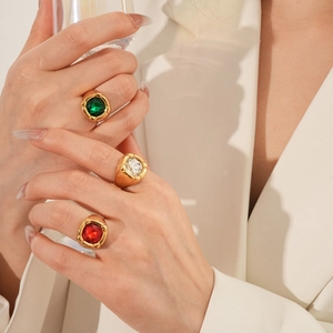 Dettaglio di anelli vintage dorati con zirconi quadrati rossi verdi e trasparenti