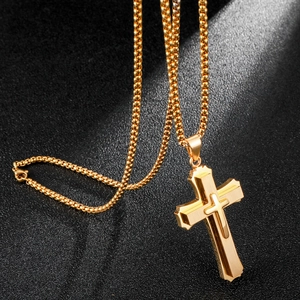 Collana con pendente a croce 3D a tre strati in acciaio dorato su sfondo scuro testurizzato