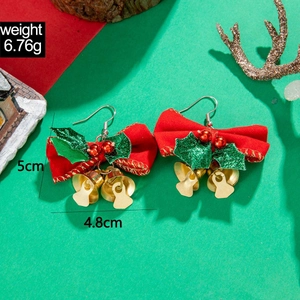 Christmas bow earrings detail with red velvet ribbon, holly leaves and golden bells