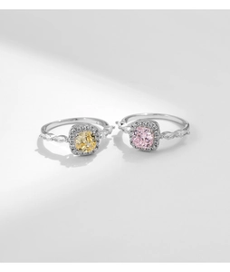 Macro detail of S925 silver rings with yellow and pink cushion-cut crystals and side stones
