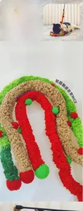 Detail of plush caterpillar cat toy wand showing soft red and green pompom textures
