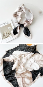 Detailed view of camellia flower pattern on satin silk scarf with hand-rolled edges