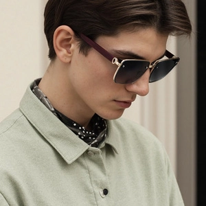 Side view of cat eye sunglasses featuring purple temples and gold reinforced hinges