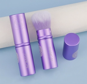 Dettaglio del pennello cipria retrattile viola con motivo a rosa e setole morbide