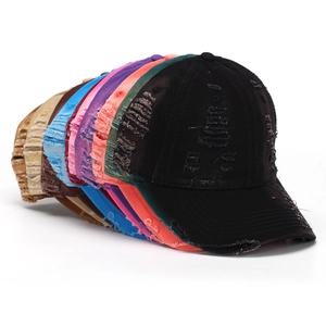 Detailed stack of distressed vintage baseball caps in various colors with ripped texture