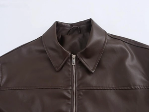 Close-up of lapel collar and metal zipper on brown vintage faux leather pilot jacket