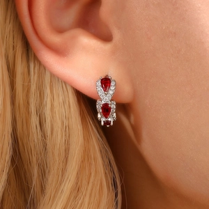 Close-up of vintage drop earrings with red zircon stones and diamonds on model