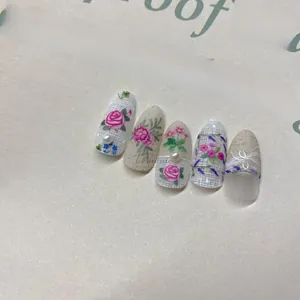 Macro detail of floral nail art with 3D pearls and lace textures on oval nails