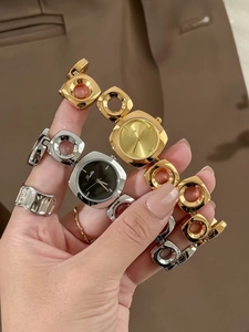 Detail showing irregular hollow bracelet watches in gold and silver with geometric chain band