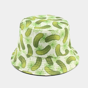 Détail d'un chapeau de soleil réversible avec motifs cornichons et aneth sur tissu beige