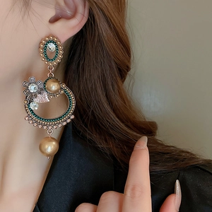 Vintage palace style earrings with champagne pearls and crystals on a female model