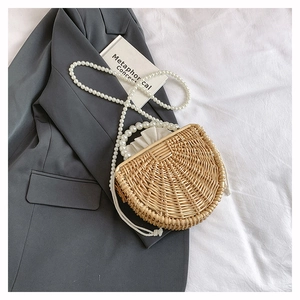 Detail of handmade semi-circle bamboo bag with large pearl handle and drawstring pouch