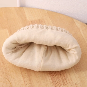 Detail shot of the cream-colored knitted winter hat featuring a soft, thick cotton lining