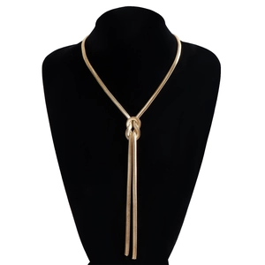 Detail of a gold knotted snake chain necklace displayed on a black velvet neck bust stand